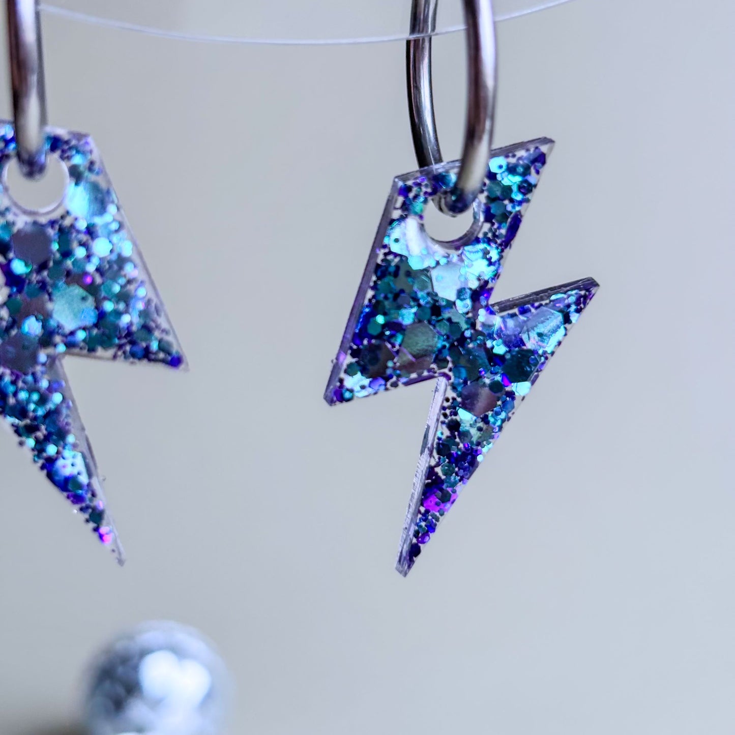 Pendientes preciosos de rayos con purpurina azul y morada