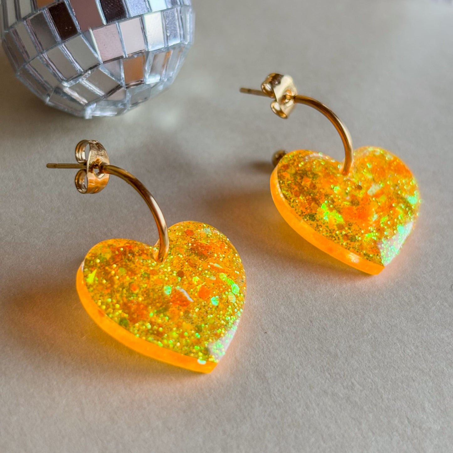 corazones naranjas con aros dorados sobre superficie plana