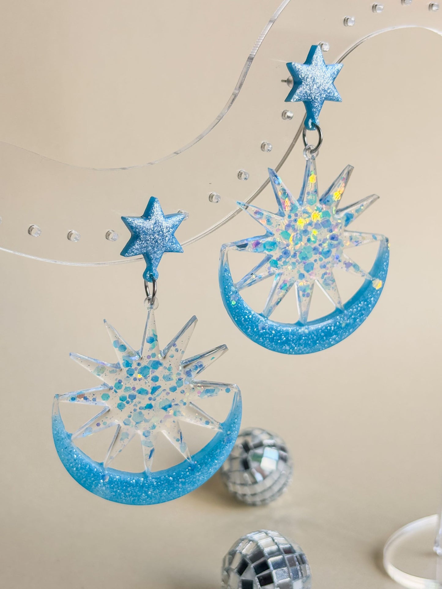 Pendientes grandes de color azul en forma de estrella, sol y luna con brillo. De resina epoxi y acero inoxidable hipoalergénico