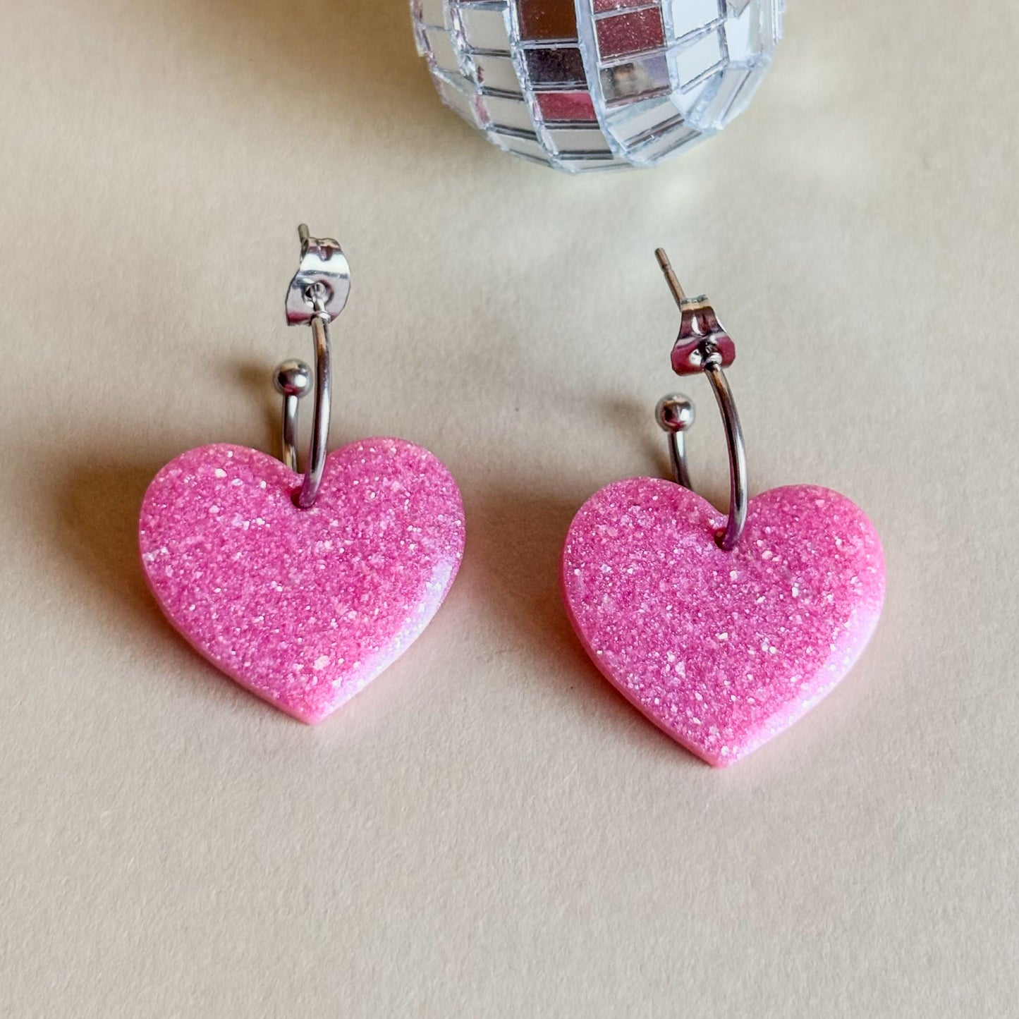Pendientes de corazones rosa palo sobre superficie plana