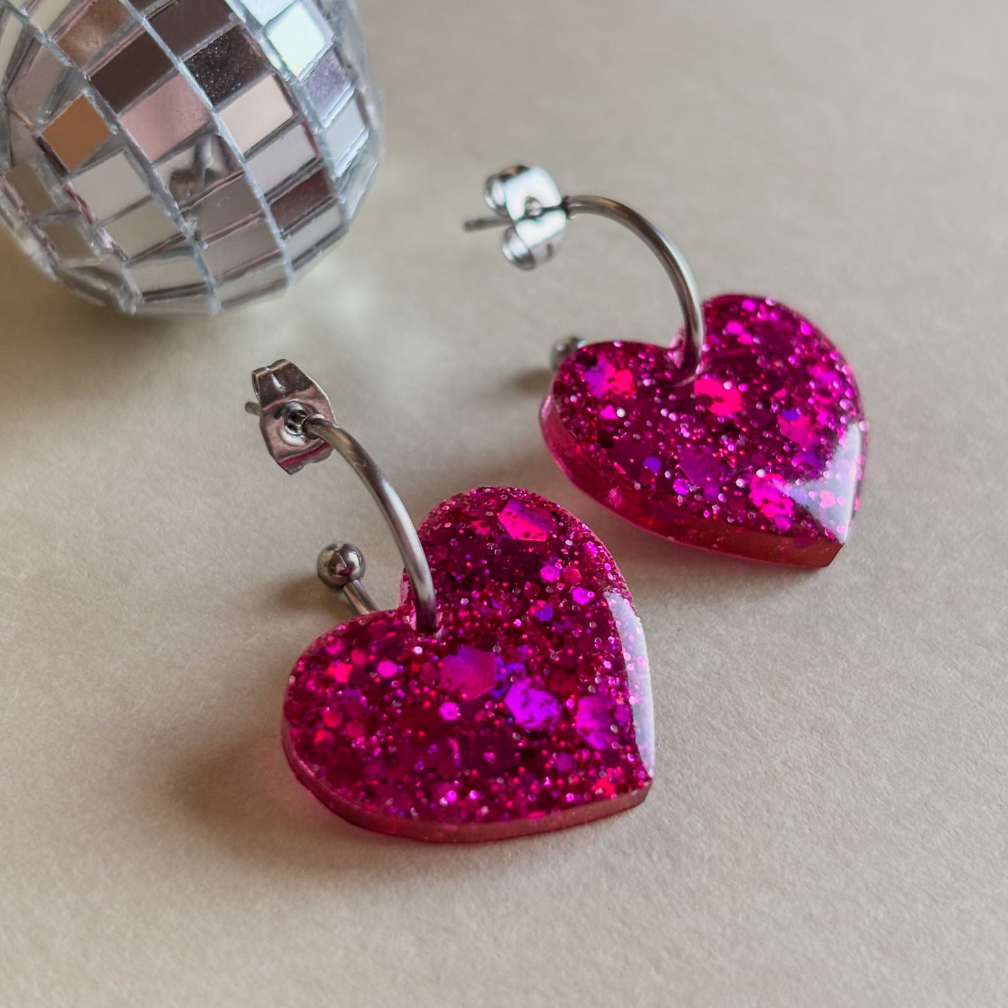 Pendientes de corazones de resina epoxi color rosa fucsia con brillo y aros plateados de acero inoxidable hipoalergénico