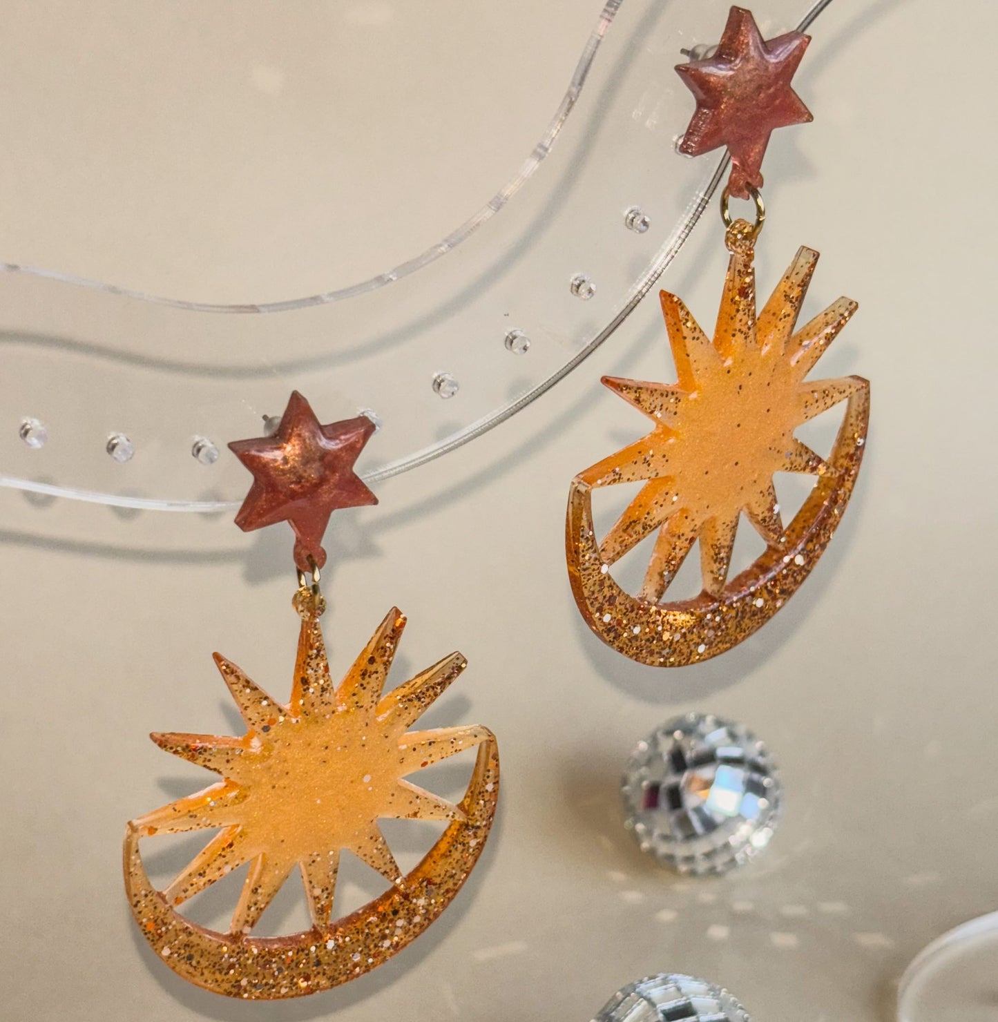 Pendientes de resina epoxi naranjas y marrones de soles, estrellas y lunas. Hipoalergénicos.