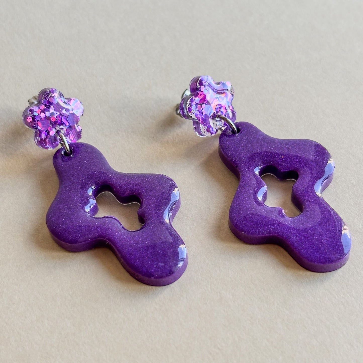 Par de pendientes de resina epoxi con forma ondulada y flor superior de color morado