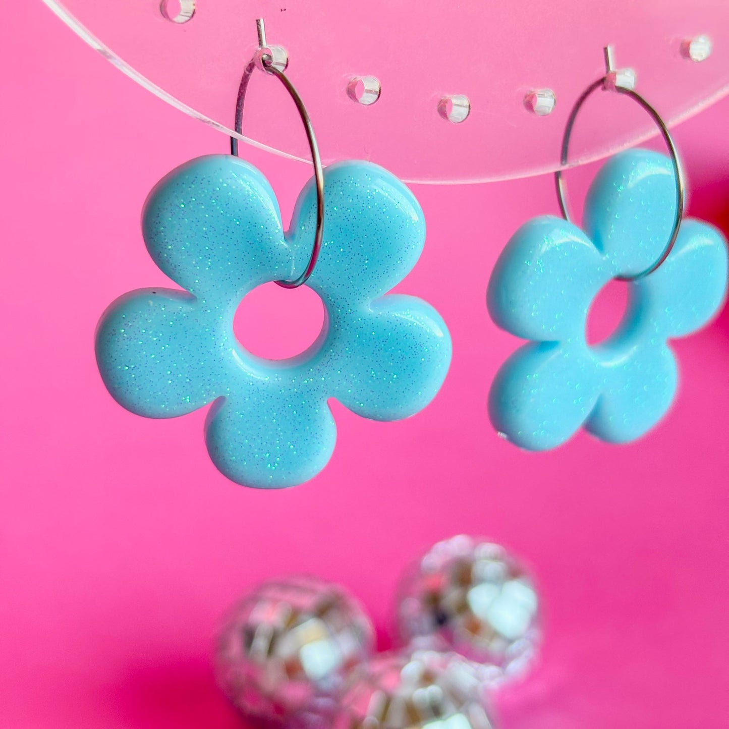 Pendientes artesanales de flores azules con brillo fino y aros plateados