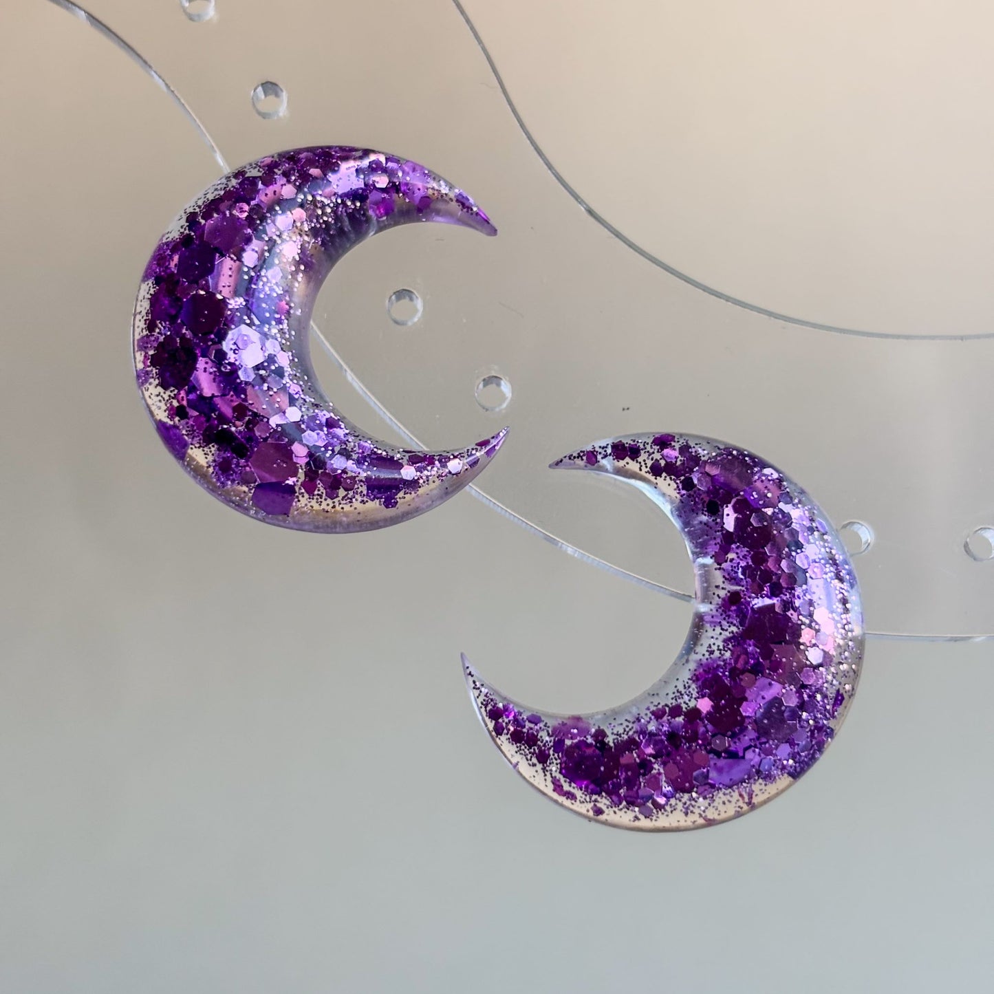 Pendientes artesanales de resina epoxi en forma de luna con brillantina lila