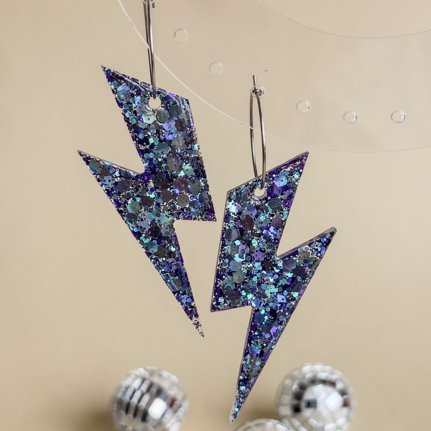 Pendientes de rayos con brillo tornasolado color azul y lila con aros plateados de acero inoxidable con luz general
