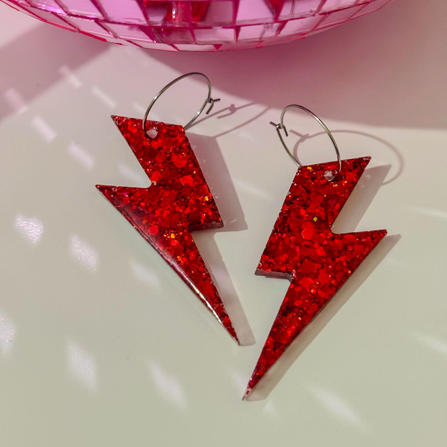 Pendientes de rayos rojos sobre superficie plana