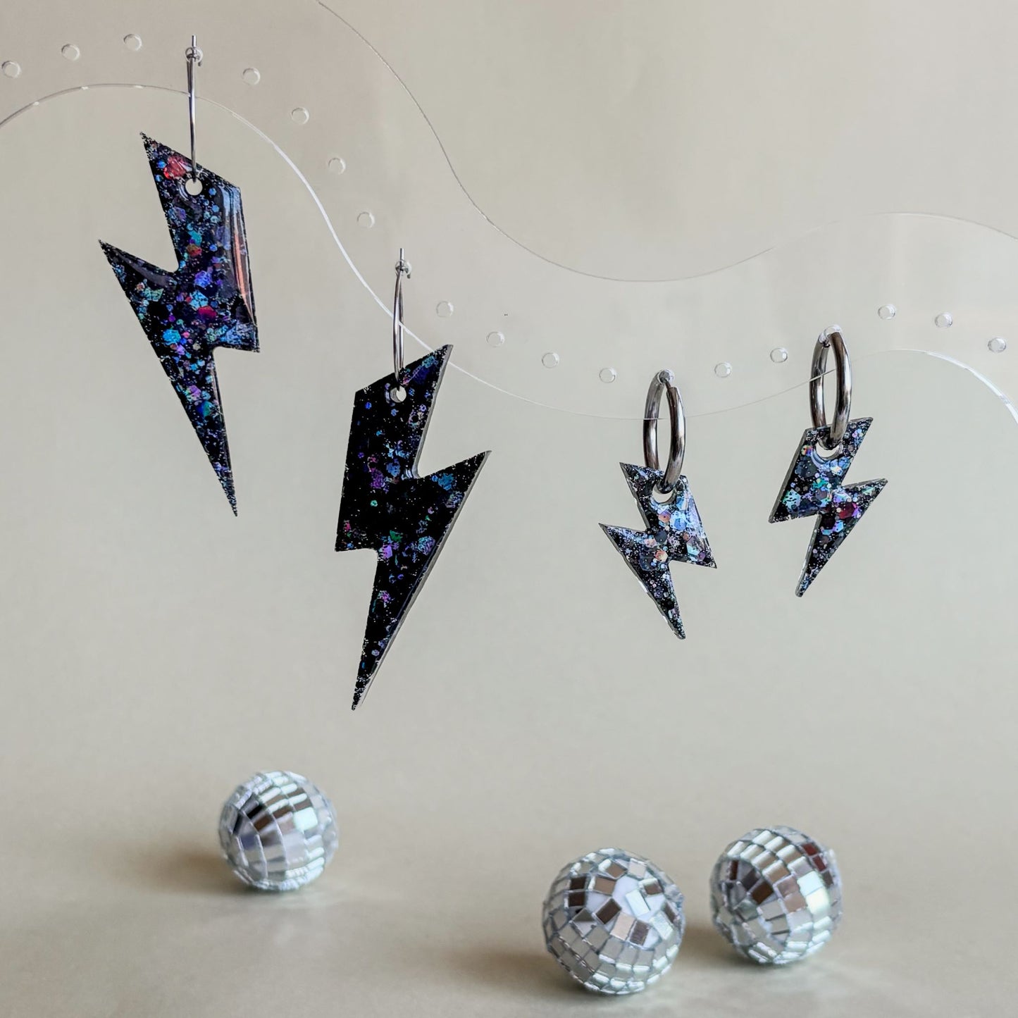 Dos pares de pendientes de rayos negros. A la izquierda, grandes; a la derecha, pequeños. No dan alergia y están hechos a mano.