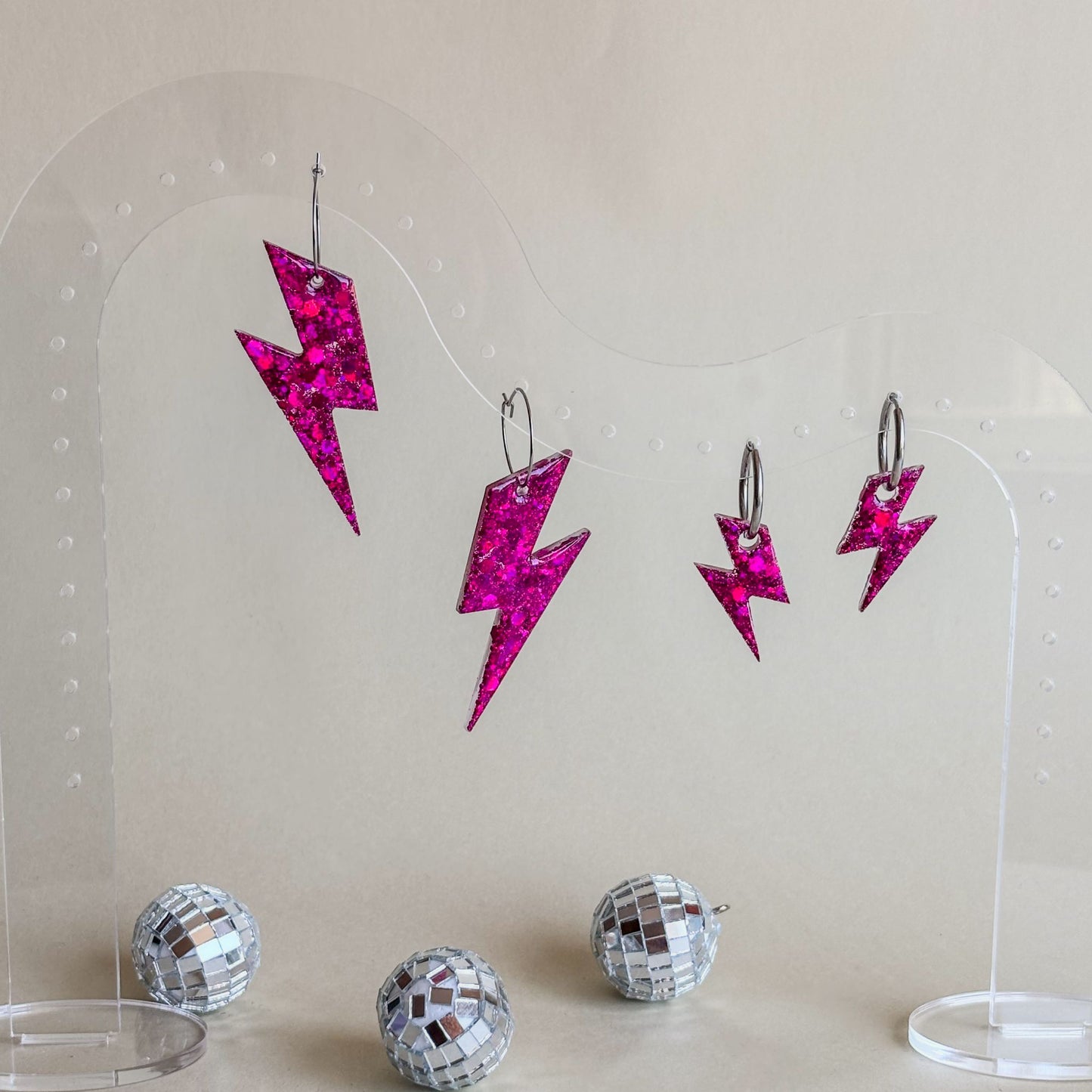 Pendientes de rayos grandes y pequeños de color rosa fucsia con acabado muy brillante. Artesanales