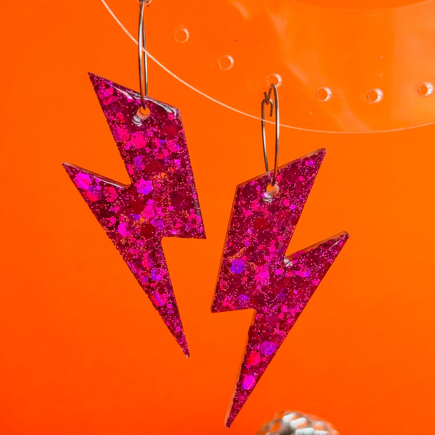 Pendientes en forma de rayos de color rosa fucsia con brillo