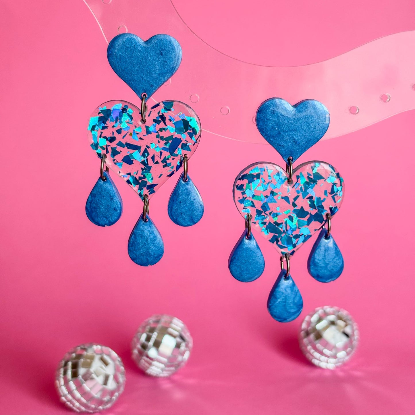 Joyería creativa. Pendientes de resina epoxi en forma de corazones con lágrimas de color azul brillante