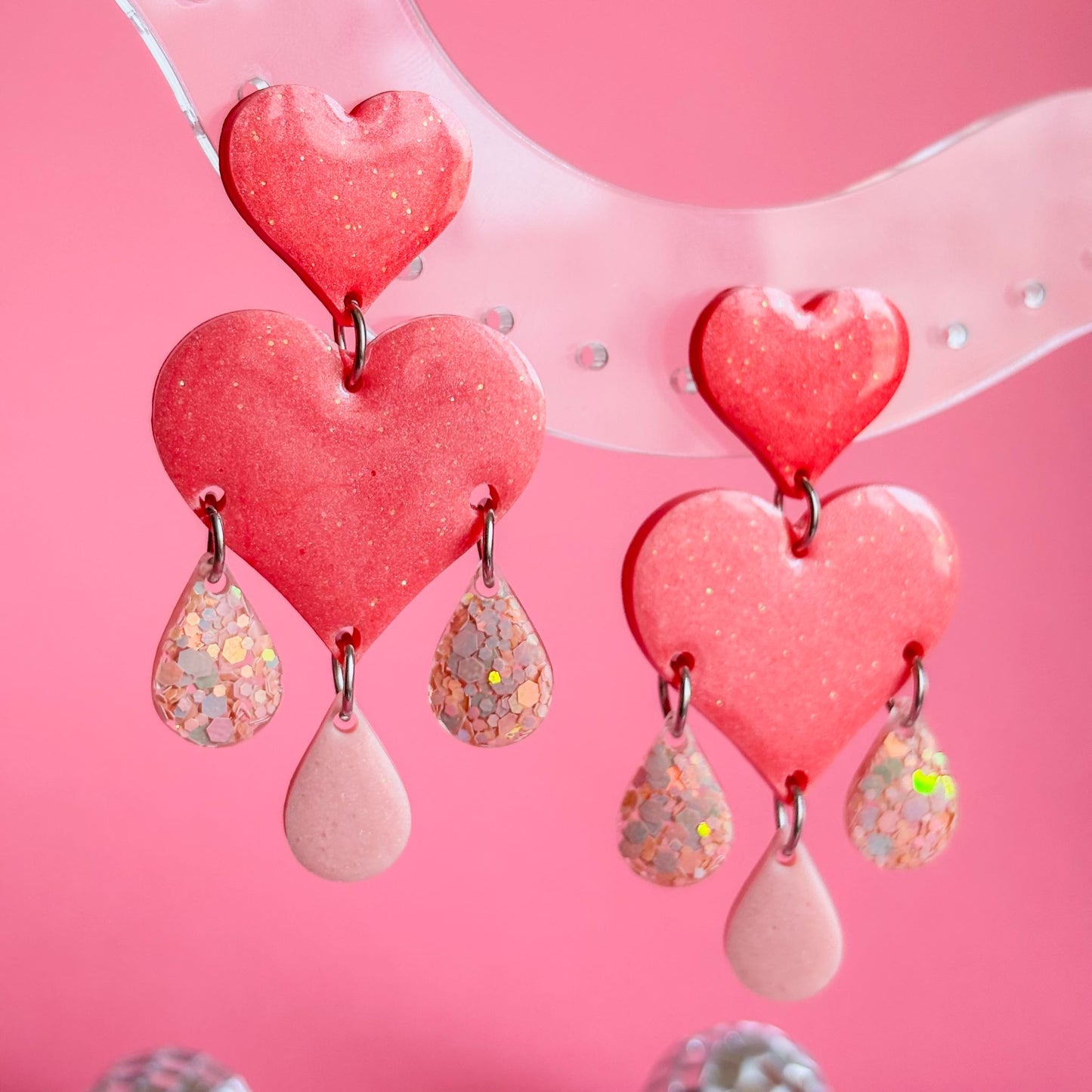 Pendientes preciosos y llamativos de resina epoxi, en forma de corazones y lágrimas de color coral y rosa. Hechos a mano en España por Doctora Irrins