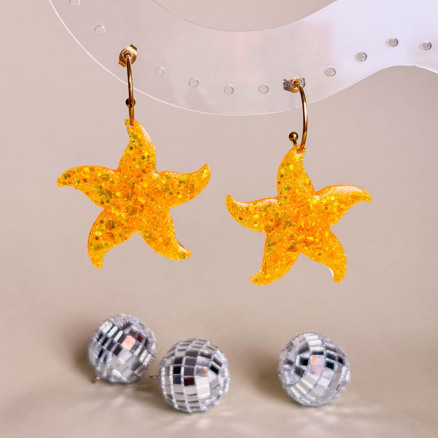 Pendientes de estrellas marinas de color naranja. Hechos a mano con resina epoxi y aros de acero inoxidable