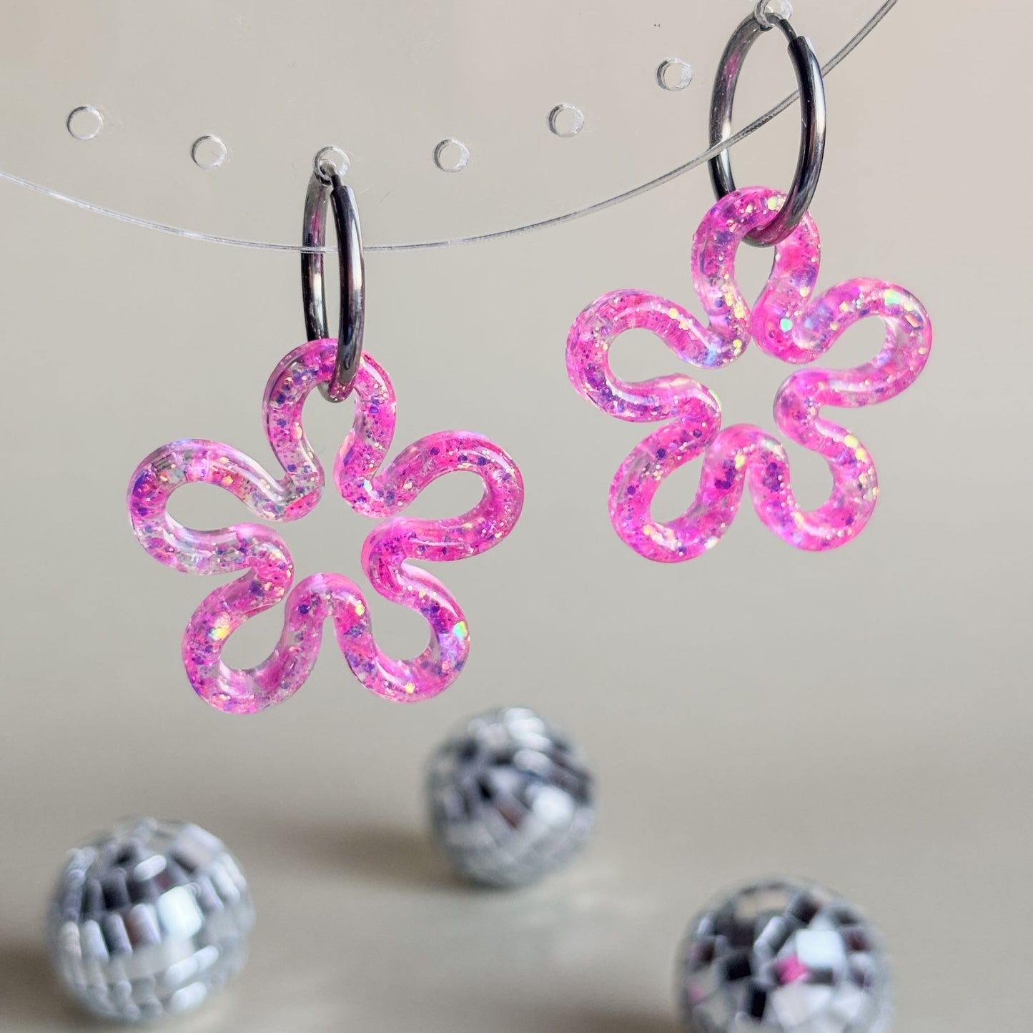 Pendientes en forma de contorno de flores rosas con aros plateados hipoalergénicos.