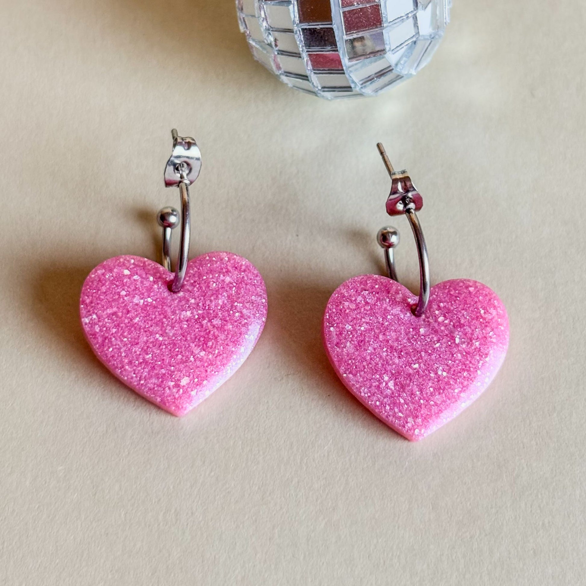 Pendientes de corazones rosa palo sobre superficie plana