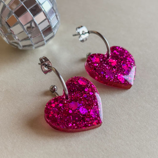 Pendientes de corazones de resina epoxi color rosa fucsia con brillo y aros plateados de acero inoxidable hipoalergénico