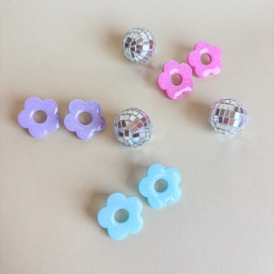 3 pares de pendientes de flores de 5 pétalos en colores pasteles: rosa, lila y azul.