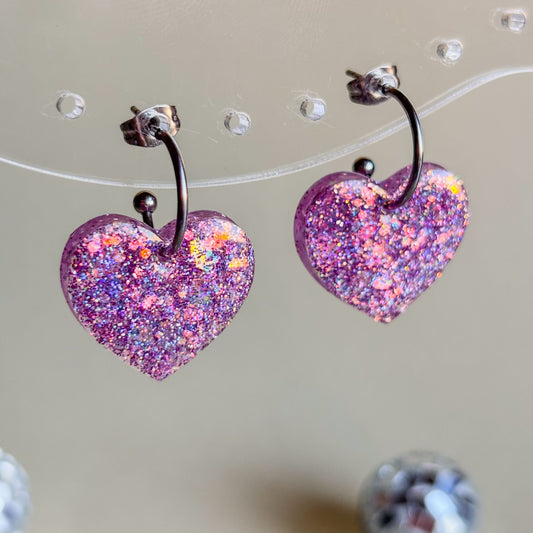 Pendientes de corazones lila pastel con mucho brillo holográfico y aros plateados