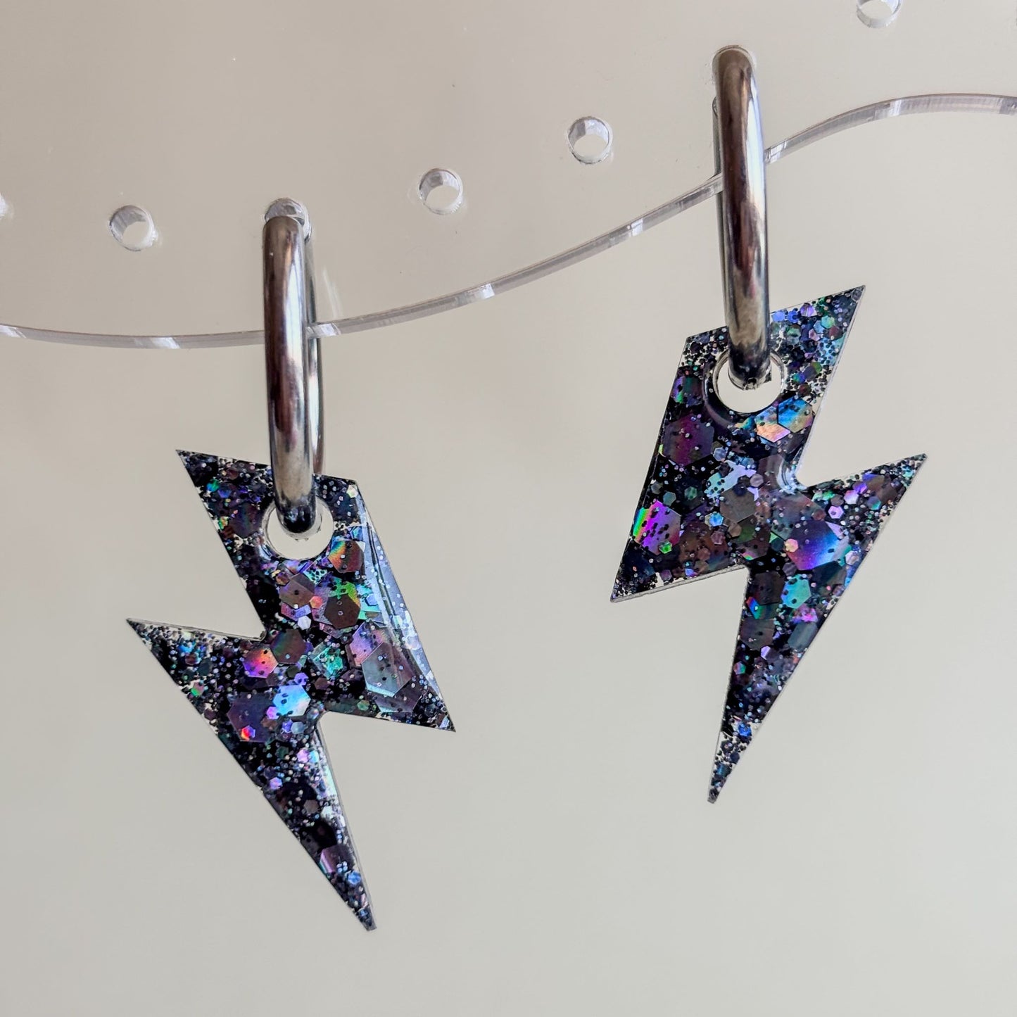 Pendientes de aros plateados y rayos negros pequeños, muy brillantes. Hechos a mano e hipoalergénicos.