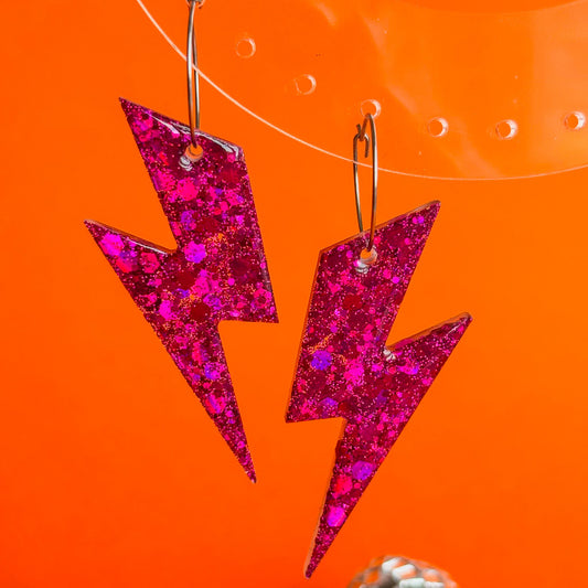 Pendientes en forma de rayos de color rosa fucsia con brillo