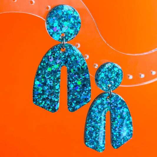 Pendientes inspirados en los destellos del sol. Color turquesa con brillo radiante y forma divertida