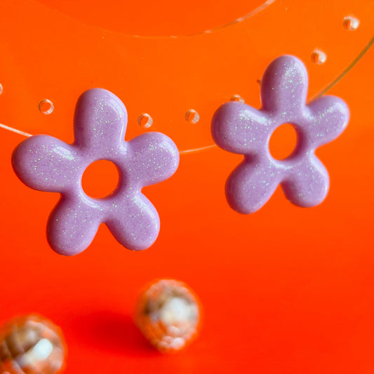 Pendientes en forma de flor de cinco pétalos alargados de color lila pastel 