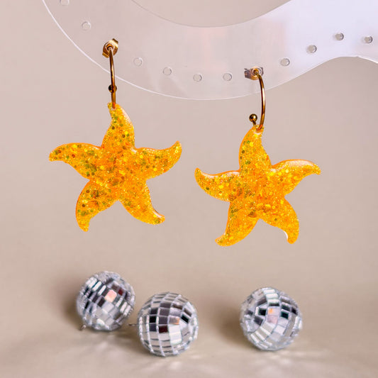 Pendientes de estrellas marinas de color naranja. Hechos a mano con resina epoxi y aros de acero inoxidable