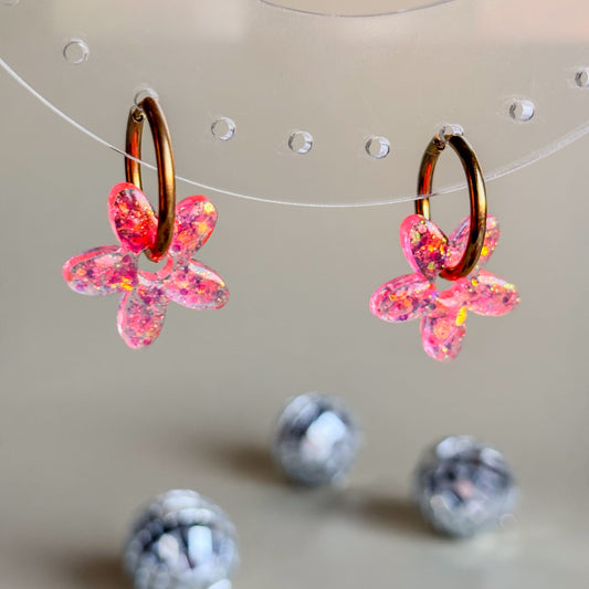 Charms de flores de resina epoxi color rosa, con aros dorados de acero inoxidable. Hechos a mano en España por Doctora Irrins.