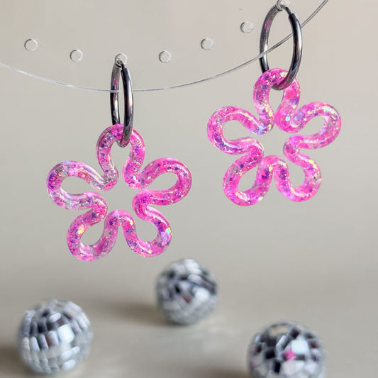Pendientes en forma de contorno de flores rosas con aros plateados hipoalergénicos.
